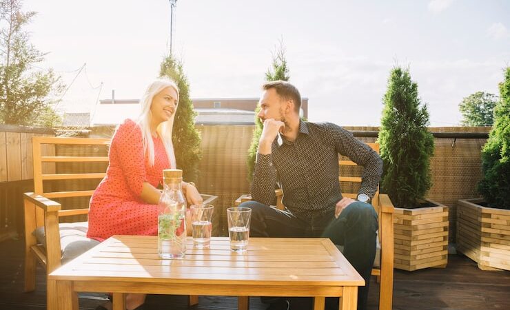 Outdoor dining space with cozy seating, greenery, and customers enjoying their meals in a relaxed atmosphere.