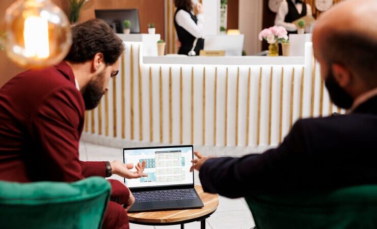 Restaurant host using a digital reservation system on a tablet while guests are being seated.